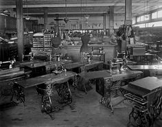 an old black and white photo of many tables in a room with lots of chairs