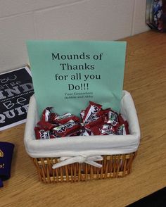 a basket filled with lots of candy sitting on top of a table next to a sign