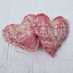 two heart shaped cushions sitting on top of a white tile floor