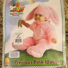 a pink rabbit costume sitting on top of a counter next to a package with an image of a baby in it