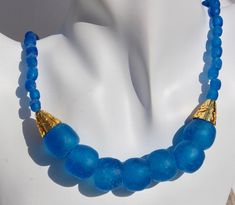 This Azure Blue African Glass Necklace makes a Beautiful Statement!  I used in this design - Recycled African Glass Made By The People of Krobo Mountain in Ghana, West Africa - Cone Shaped Gold Plated Bead Cap Accents, Gold Plated Hook and Eye Clasp, 18".   I have a matching bracelet, sold separately.  This would make a gorgeous set! Adjustable Blue Beaded Necklaces With Bead Caps, Handmade Blue Beaded Necklaces With Recycled Glass, Traditional Blue Glass Necklaces, Handmade Blue Recycled Glass Beaded Necklaces, Blue Beaded Necklace In Recycled Glass, Blue Recycled Glass Bead Necklaces, African Shell Necklace, Blue Murano Glass Beaded Necklace With Large Beads, Handmade Blue Recycled Glass Necklace