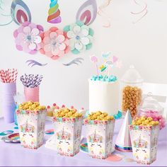 a table topped with lots of cakes and cupcakes on top of paper bags