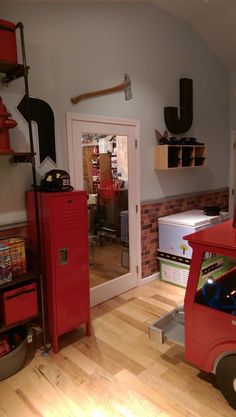 a red truck is parked in the middle of a room with shelves and other items