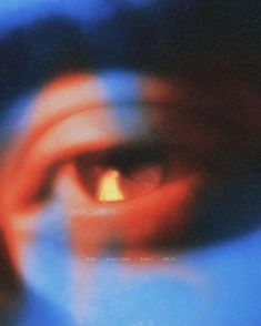 blurry image of an eye in front of a blue background with red and yellow colors