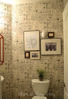 a bathroom with a toilet and pictures on the wall above it that says how to hang wallpaper