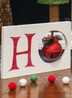 a christmas ornament in the shape of a letter h is hanging on a table