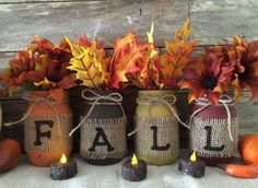 three mason jars with fall decorations in them