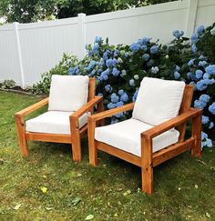 two wooden chairs sitting next to each other in front of blue hydrangea flowers