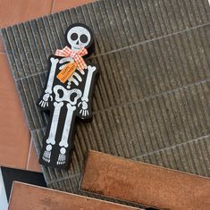 a wooden skeleton with a bow on it's head is laying on the ground