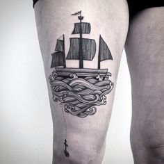 a woman's thigh with a ship tattoo on it