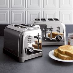 two pieces of toaster sitting on top of a table next to a plate with peanut butter and jelly