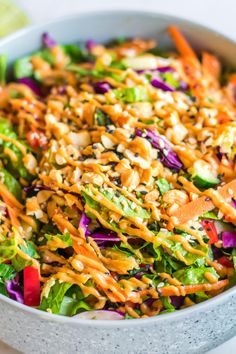 a salad with carrots, lettuce, and other vegetables in a bowl