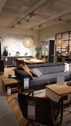 a living room filled with lots of furniture and decor on top of hard wood flooring