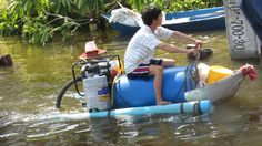 a young boy riding on the back of a blue boat