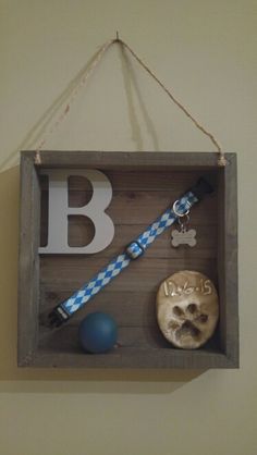 a wooden box with a tie and other items hanging from it's side on a wall