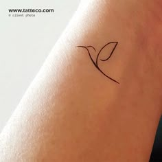 a small tattoo on the arm of a woman's left arm, with a single leaf