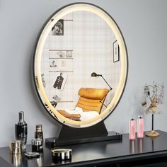 a round mirror sitting on top of a desk next to a lamp and other items