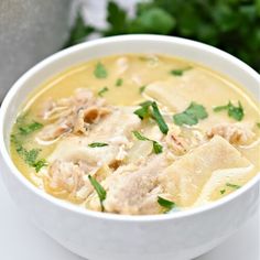 a white bowl filled with soup and meat