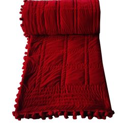 a red blanket with pom poms on the bottom and bottom, in front of a white background