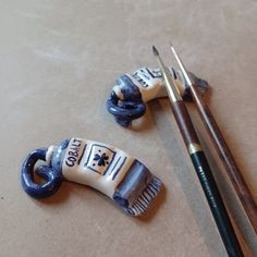 two brushes and some ceramic figurines sitting next to each other