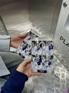 a person holding up several polaroid pictures in front of a metal object with the word play on it