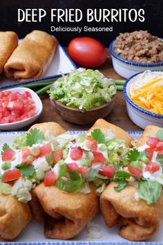 deep fried burritos with salsa, lettuce and tomatoes on the side