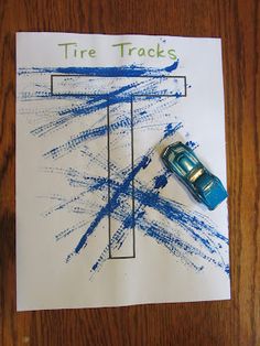 a piece of paper with a blue car on it and the words tire tracks next to it