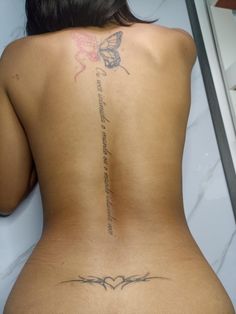 the back of a woman's body with tattoos on it