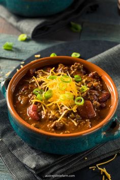 a bowl filled with chili and cheese on top of a table