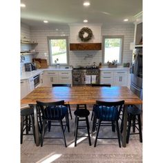 a kitchen table with four chairs in front of it and an oven on the other side