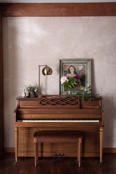 an old piano in a room with a painting on the wall