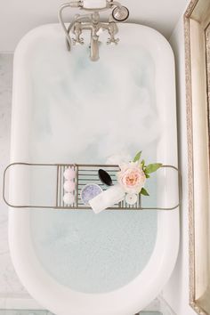 a bathtub with soaps and flowers in it