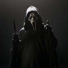 a person in a hooded costume holding a knife