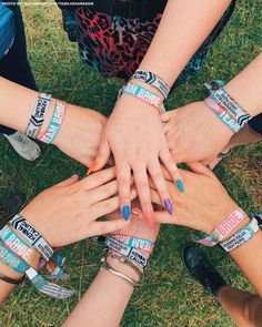 several people with their hands together in the middle of each other's arms, all wearing bracelets