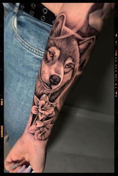 a woman's arm with a wolf and flowers tattoo on the left side of her arm