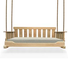 a wooden swing bed hanging from a rope on an isolated white background with room for text