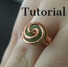 a person's hand with a ring on it that has an image of a spiral design