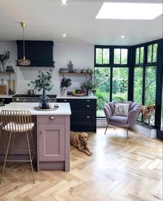 a kitchen with black cabinets and white counter tops next to a wooden flooring area