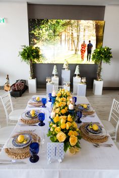 a table set with yellow flowers and blue plates