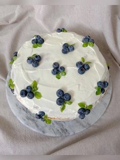 a cake with white frosting and blueberries on it