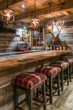 a bar with stools and deer heads on the wall