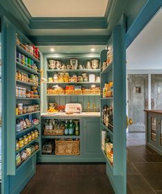 an open pantry filled with lots of food and condiments in blue painted walls