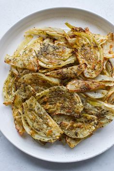 a white plate topped with cooked artichokes on top of a table