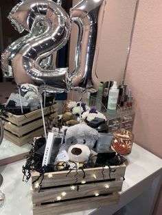 a table topped with lots of silver balloons and other items next to a mirror filled with bottles