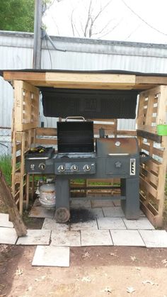 an outdoor bbq grill built into the side of a building with wood pallets