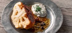 a silver plate topped with food on top of a wooden table