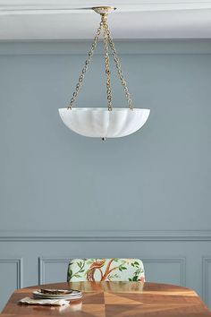 a dining room table and chairs with a chandelier hanging from the ceiling