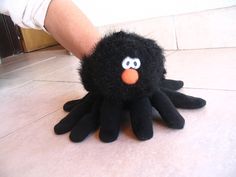 a stuffed animal that looks like an octopus is being held by someone's hand