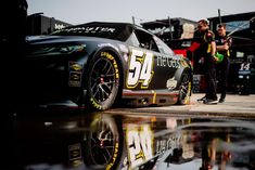 a man standing next to a racing car