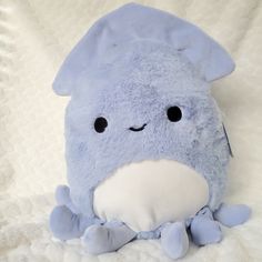 a blue stuffed animal sitting on top of a bed